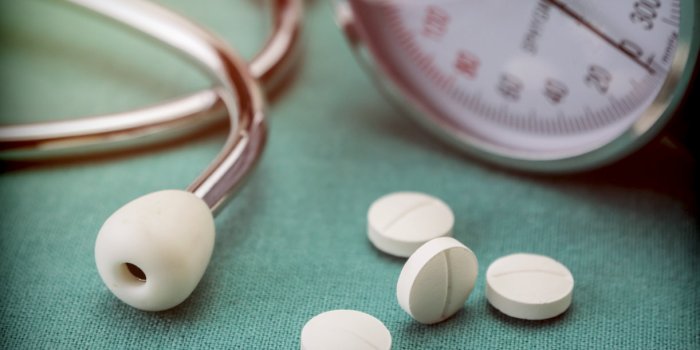white pad next to a manometer to measure blood pressure and a stethoscope in a hospital, conceptual image
