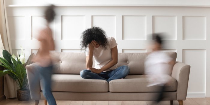 frustrated stressed single african mom having headache feel tired annoyed about noisy active kids playing at home, upset ...