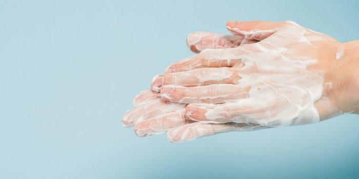 cropped view of man washing hands on blue
