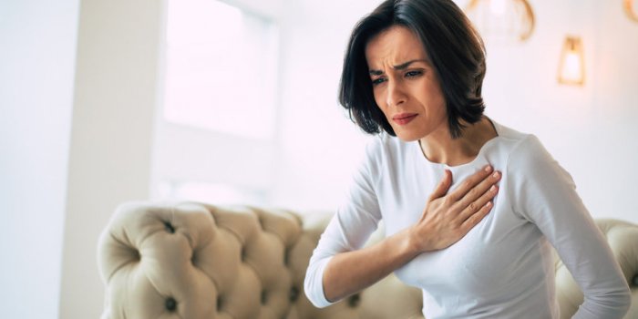 pressure in the chest close-up photo of a stressed woman who is suffering from a chest pain and touching her heart area