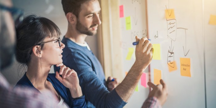 business people meeting at office and use post it notes to share idea brainstorming concept sticky note on glass wall