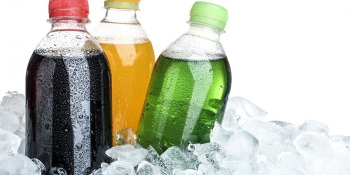 ice cubes and different soda drinks on white background
