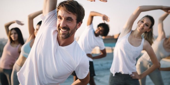 fitness, sport, friendship and healthy lifestyle concept - group of happy friends or sportsmen exercising