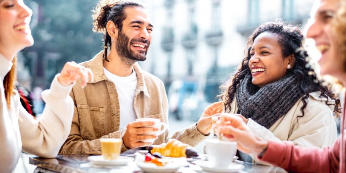 young couples drinking cappuccino at coffee bar patio - friends talking and having fun together at sidewalk cafeteria - l...