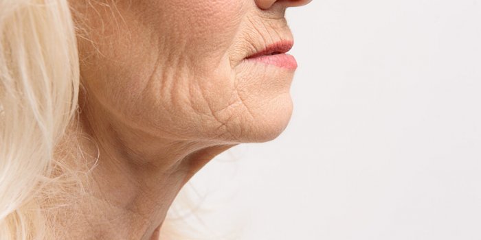 wrinkles at face and neck of woman close up isolated copy space on right side