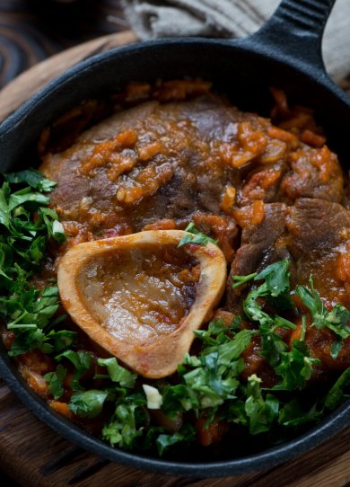 close-up of ossobuco with gremolata in a frying pan, studio shot