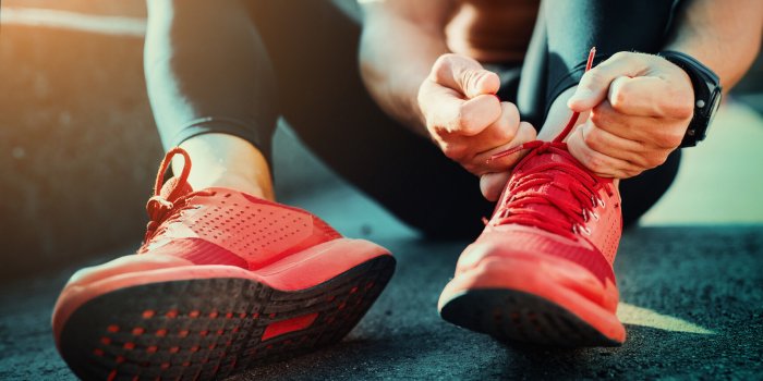 man tying jogging shoeshe is running outdoors on a sunny day