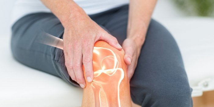 mid section of man suffering with knee cramp
