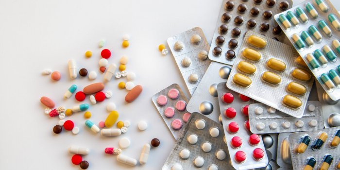 blisters with various pills and capsules on a white background with copy space medicine, pharmaceuticals, treatment and p...