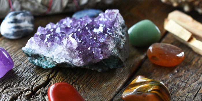 a close up image of chakra crystals surrounding am amethyst geode cluster