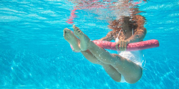 sporty woman doing water aerobics in a pool with a buoy