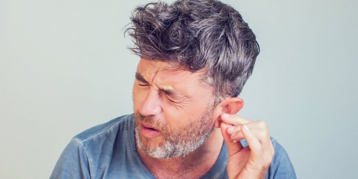 man with ear sticks on a light background care