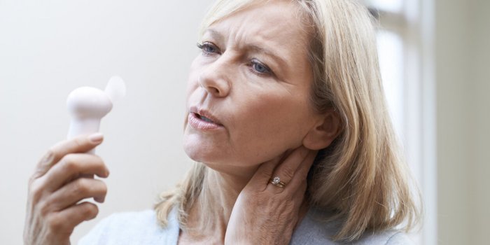 mature woman experiencing hot flush from menopause