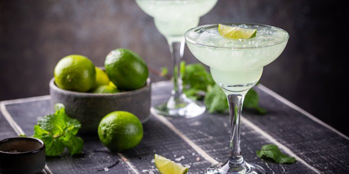 margarita cocktail with lime in a glass on dark background