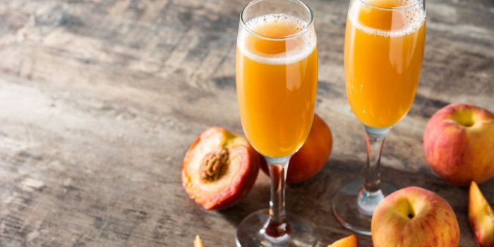 bellini champagne cocktail in crystal glass on wooden table