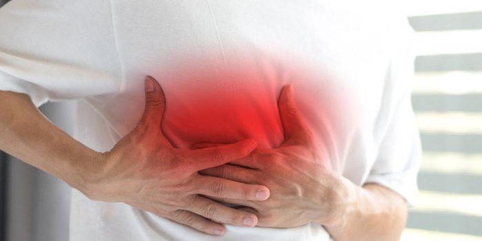 man's hands on his chest in white shirt with red spot as suffering on chest pain male suffer from heart attack,lung probl...