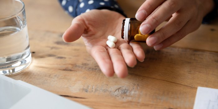 close up of unhealthy young woman take antibiotics or antidepressant at home, unwell millennial female feel ill drink pre...