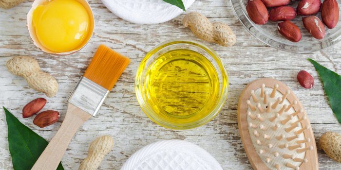 small glass bowl with peanut (groundnut) oil and raw egg yolk natural face and hair mask recipe ingredients of homemade c...