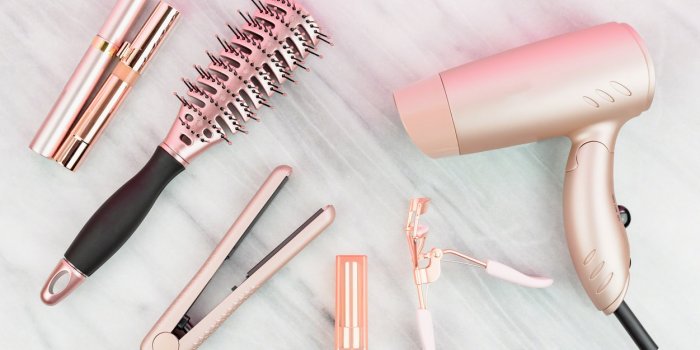 rose gold hair care and beauty products on marble countertop