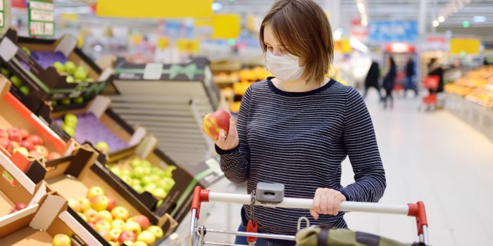 young woman wearing disposable medical mask shopping in supermarket during coronavirus pneumonia outbreak protection and ...