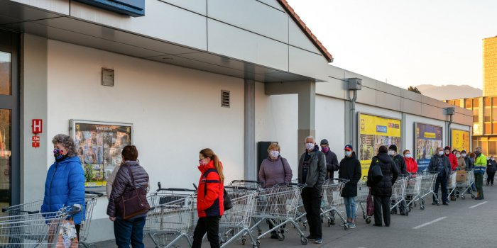 ruzomberok, slovakia - april 2 long line of people with face masks and shopping cart in front of grocery