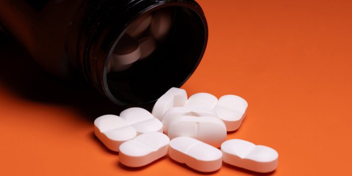 gesundheit, deutschland, rheinland-pfalz, medikamentenflasche kippt auf orange grund, tabletten verstreut perfekt für ge...