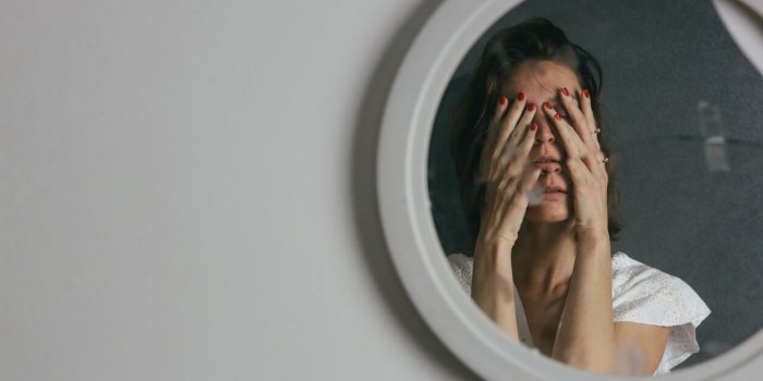 reflection of a woman's face in broken mirror depression, anxiety, phobia, suicide and mental health concept