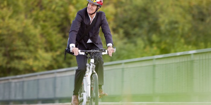 businessman riding bicycle on bridge