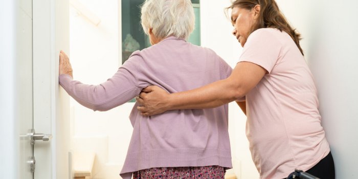 caregiver help asian or elderly old woman sitting wheelchair support up the stairs in home
