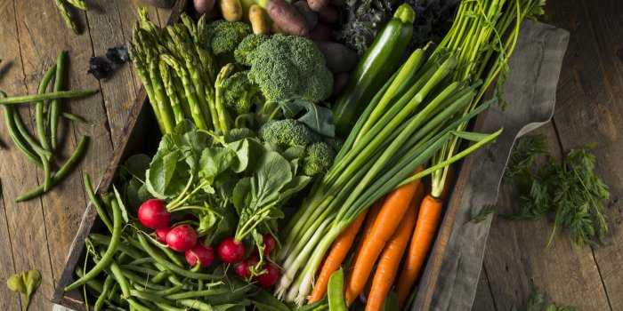 raw organic spring farmers market box with asparagus broccoli kale snow peas and green onions