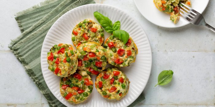 mixed vegetable flans made with ricotta cheese, egg, carrot, green peas, zucchini and tomato oven baked vegetarian colorf...