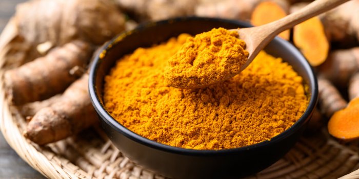 turmeric powder and fresh turmeric (curcuma, curcumin), organic ingredient in asian cuisine, food coloring or natural dyeing