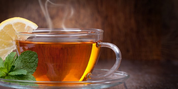 cup of tea with mint and lemon on a wooden background