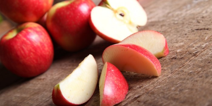 red apple and slices on barn wood