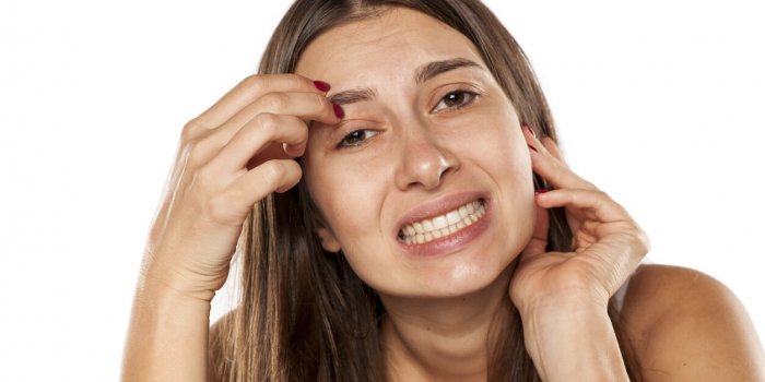 nervous young woman has an itch in eyebrows
