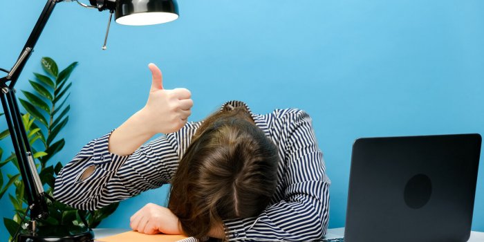 tired exhausted secretary employee business woman in shirt sitting work sleep laid her head down on office desk with pc l...