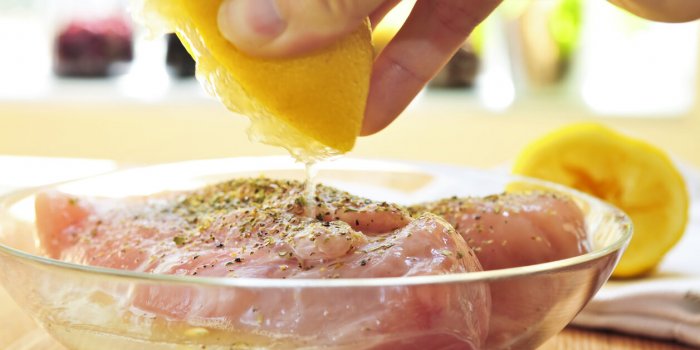marinating raw chicken breasts in lemon juice and herbs