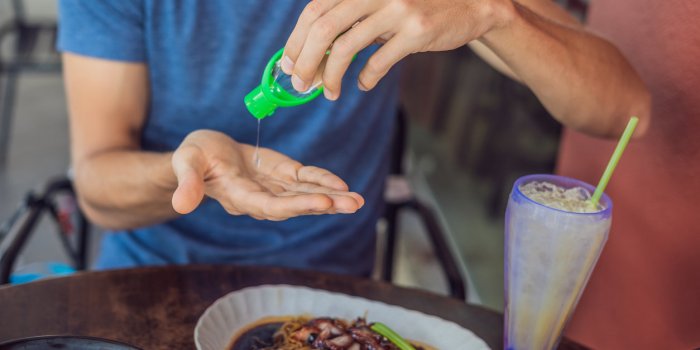 men's hands using wash hand sanitizer gel pump dispenser