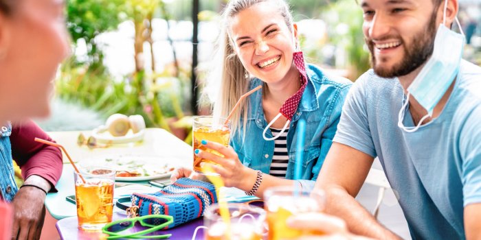 friends drinking at cocktail bar with opened face masks - new normal friendship concept with people having fun together t...