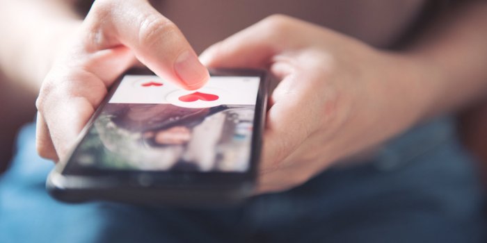 finger of woman pushing heart icon on screen in mobile smartphone application online dating app, valentine's day concept