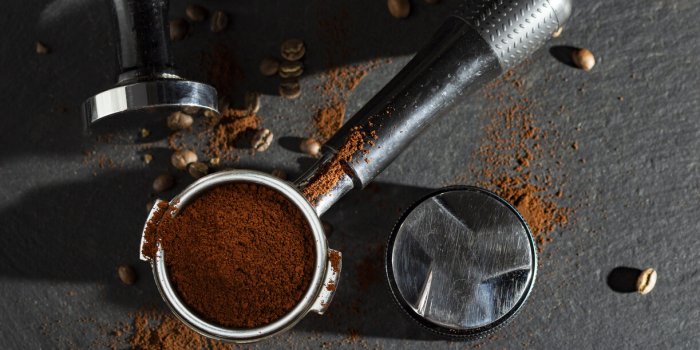 portafilter with coffee and temper on table