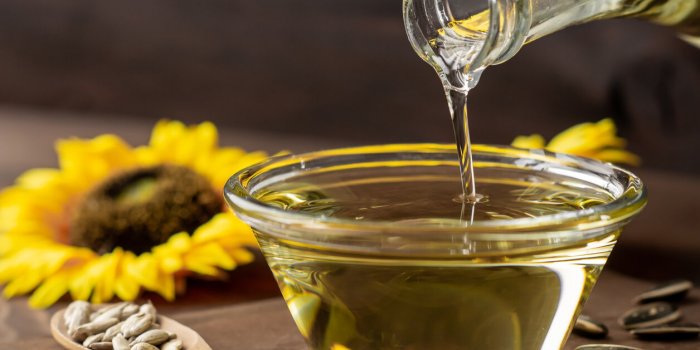 cooking oil pouring from bottle, sunflower seed oil, kitchen preparing, helianthus annuus