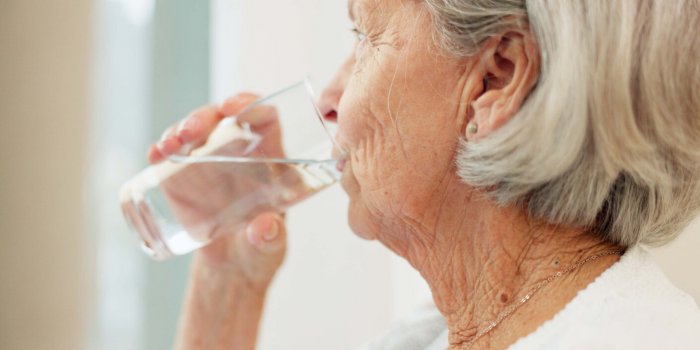 healthy, hydration and senior woman drinking water for wellness and liquid diet detox at home thirsty, fresh and calm eld...