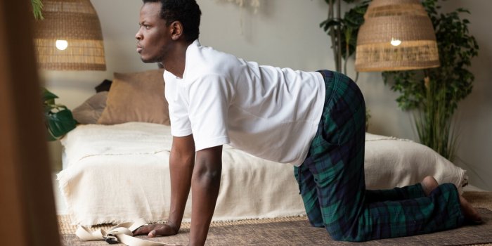 sporty muscular young african man working out, yoga, pilates, fitness training, bend in cow yoga posture, bitilasana