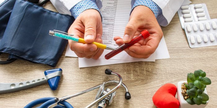 doctor during consultation held in his hand and shows patient laboratory tube with blood counseling of transfusion, blood...