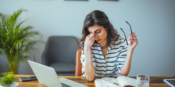 exhausted businesswoman having a headache in modern office mature creative woman working at office desk with spectacles o...