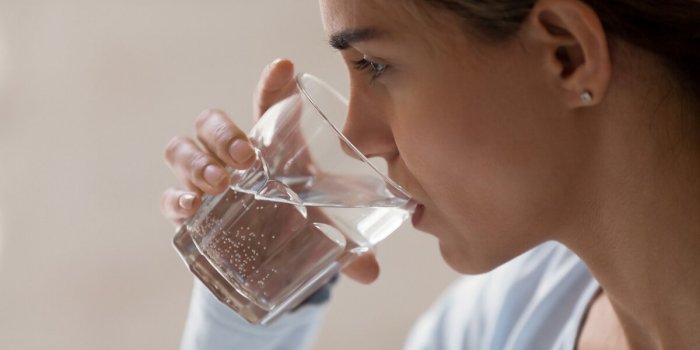 closeup profile portrait of woman drinking pure water from glass beautiful young brunette female feeling thirsty, making ...