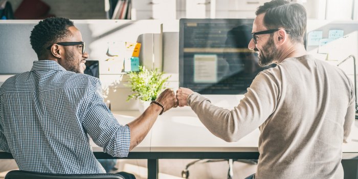 first bump between colleagues at work success in business everyday work in the office