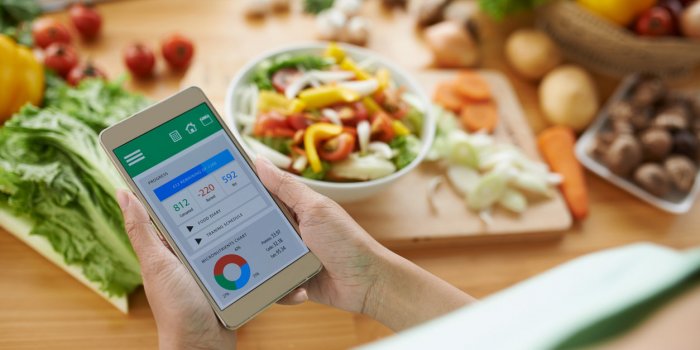 woman using calorie counter application on her smartphone