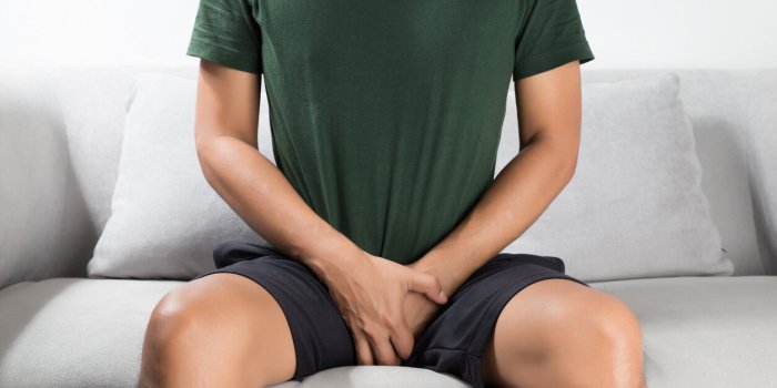 asian man wants to pee and is holding his bladder
